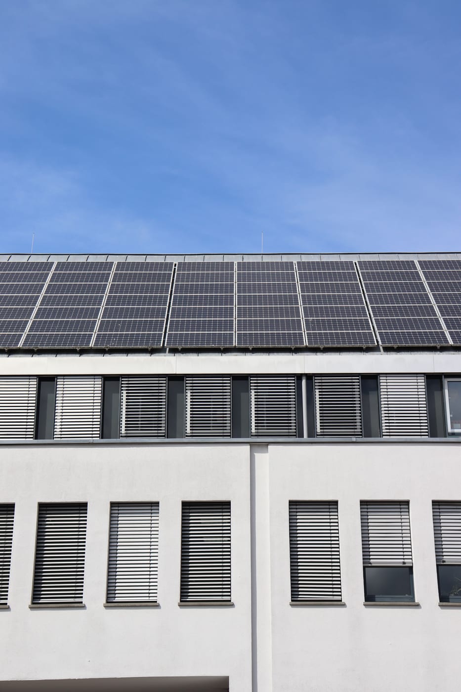 Vom Dachdecker montierte Photovoltaikmodule auf dem Dach eines mehrgeschossigen Gewerbegebäudes