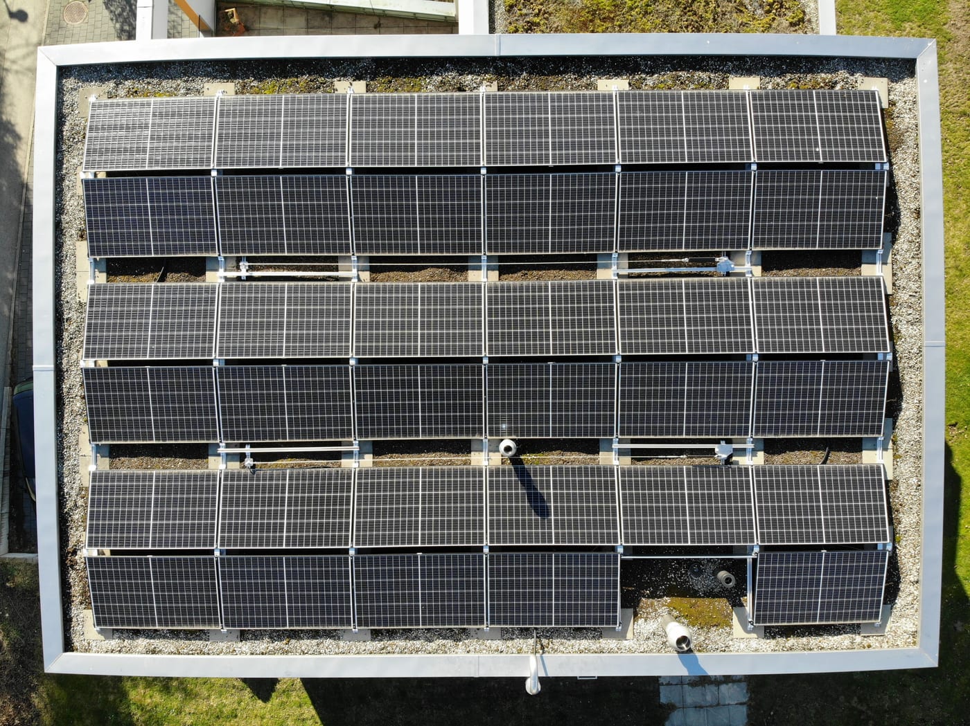 Luftaufnahme eines vom Dachdecker abgedichteten Flachdachs mit aufgeständerter Photovoltaikanlage